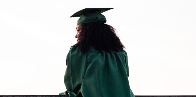 Black graduate in cap and gown at graduation