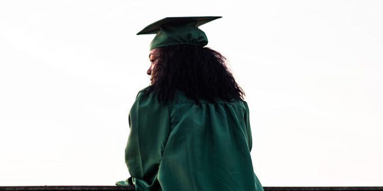 Black graduate in cap and gown at graduation