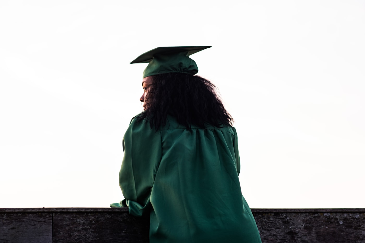 Black graduates in caps and gowns celebrating at commencement