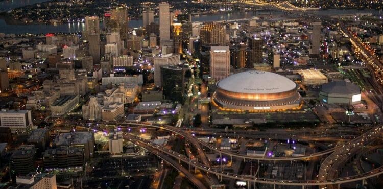 Aerial view of the New Orleans skyline at dusk, showing the Superdome and downtown