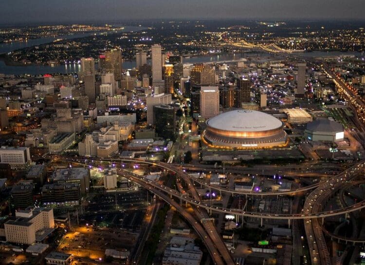 Aerial view of the New Orleans skyline at dusk, showing the Superdome and downtown