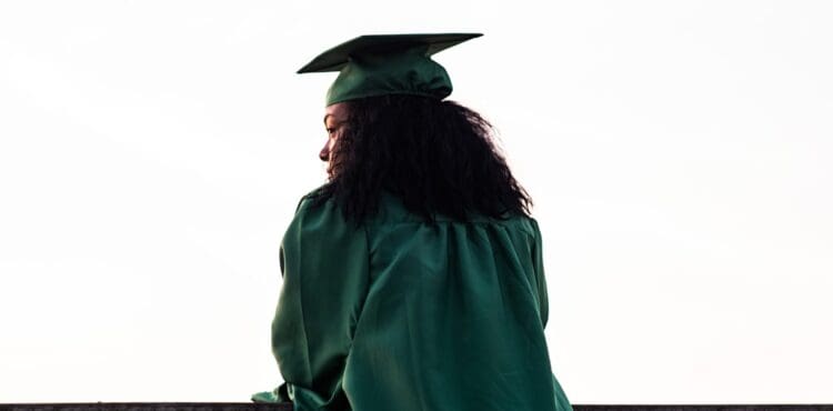 Black graduate in cap and gown at graduation